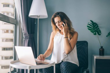 Modern dizüstü bilgisayar aygıtında uzaktan çalışan yetenekli kadın serbest yazar e-posta aldı ve iş arkadaşını başlangıç projesi, çoklu görev ve iletişim konseptini tartışmak için çağırdı