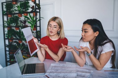 Çok ırklı kadınlar ofiste belgeleri kontrol ediyorlar