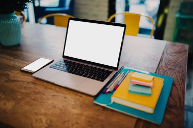 Ahşap, temiz, dizüstü bilgisayar, mavi defter, renkli kalemler, sarı kitap çıkartmaları, cep telefonu fabrikası, şehirdeki kafe.