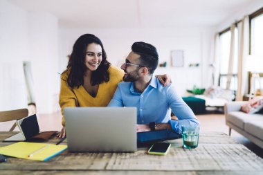 Dizüstü bilgisayarda çalışan birkaç tele-işçi, dizüstü bilgisayarda başarılı bir şekilde anlaştıktan ve birbirlerine baktıktan sonra gülümseyen kadın ve erkeklerden hoşlanıyor.