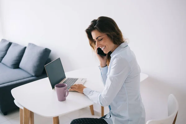 Vista Lateral Morena Sorrindo Jovem Sentada Perto Xícara Laptop Com — Fotografia de Stock