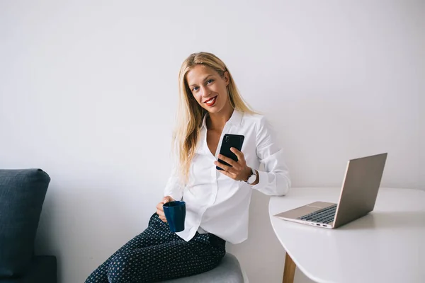 Satisfecho Feliz Joven Mujer Rubia Inteligente Apoyándose Mesa Blanca Manteniendo —  Fotos de Stock