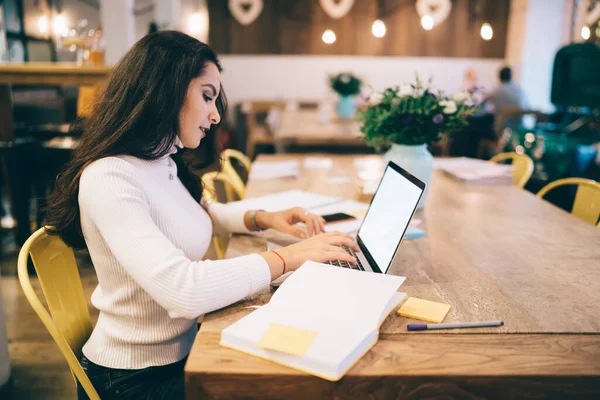 在现代工作场所 一位有着一头乌黑长发 身穿白衣的聪明女士坐在桌旁 手握笔记本电脑 手握彩色贴纸笔尖笔 — 图库照片