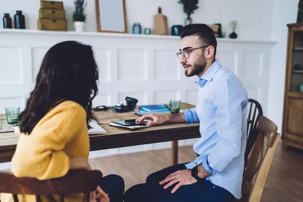 Gözlüklü, kendine güveni tam ve pozitif bir adam. Yeni iş projesinin detaylarını tartışan gündelik giysiler içindeki kadın girişimciyi dikkatle dinliyor. 