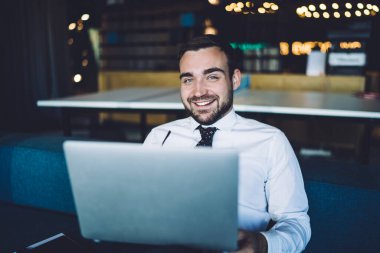 Şirket işyerinde oturan neşeli erkek girişimcinin portresi ve bitcoin analizi için zaman içinde kameraya gülümseyen ticari sitelerde şifreli para değişimi, dizüstü bilgisayar yatırımı