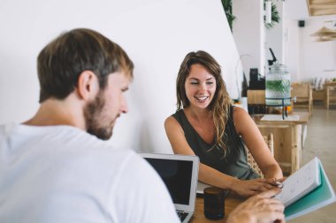 Neşeli, çekici genç bayan ve yakışıklı yetişkin erkek defter kağıdını hesaplayarak hem evde oturup hem de tatil planlıyorlar.