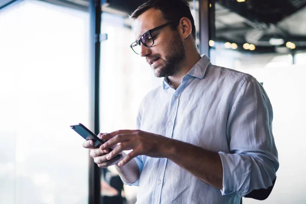 在贸易网站上 困惑的金融专家在接收手机短信的同时 还阅读了困惑的男性专业主管的短信 以解决智能手机模式下的企业问题 — 图库照片