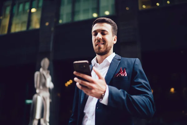 Baixo Ângulo Empreendedor Confiante Uso Formal Smartphone Navegação Sorrindo Enquanto — Fotografia de Stock