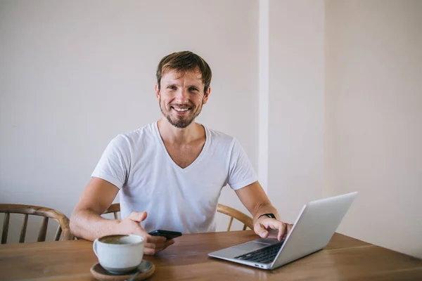 Glad Man Vita Kläder Sitter Ljust Rum Med Mugg Kaffe — Stockfoto