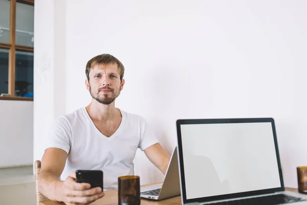 Tankeväckande Stilig Vuxen Man Bär Enkel Vit Shirt Håller Telefon — Stockfoto