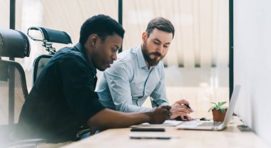 Zarif giysiler içinde çalışkan, dikkatli, çeşitli girişimcilerin düşük açısı büyük pencereye karşı masasında cihazlarla otururken hesaplamalar yapıyor ve sonuç üzerinde kafa yoruyor