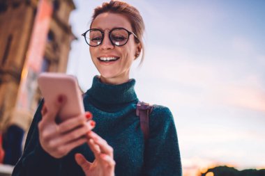 İnternette turistlerin sanal iletişimden hoşlandığı internet sitesinde sohbet ederken gülen modaya uygun gözlüklü, gülen mutlu kadın blogcuların altında komik yorumlar okuyan kaygısız kadın blogcu