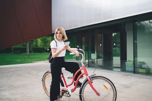 스마트폰을 사용하여 평상복을 거리에 자전거를 시선을 돌리는 생각깊은 자전거타기 — 스톡 사진
