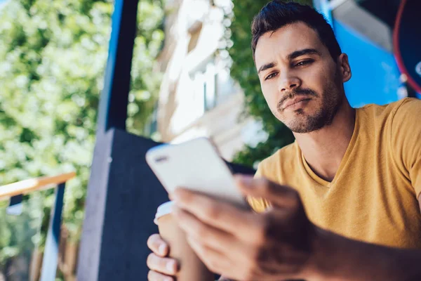 Alulról Komoly Alkalmi Férfi Sárga Pólóban Ellenőrzi Üzenetet Mobiltelefonon Miközben — Stock Fotó