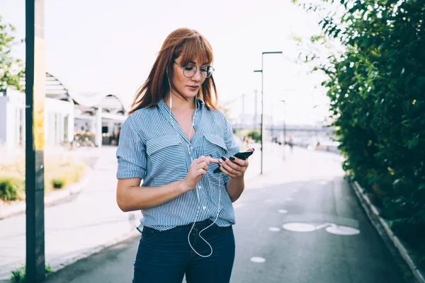 Günlük Giysiler Içindeki Genç Bir Kadın Cep Telefonu Kulaklık Kullanıyor — Stok fotoğraf