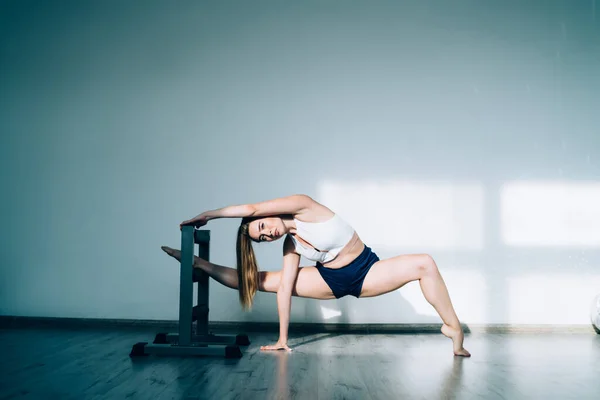 Sportliche Hündin Mit Pferdeschwanz Und Shorts Mit Top Stretching Bein — Stockfoto