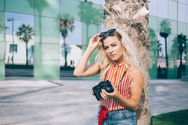 Young Fair Haired Female Fixing Sunglasses Head Looking Camera While — Stock Photo, Image