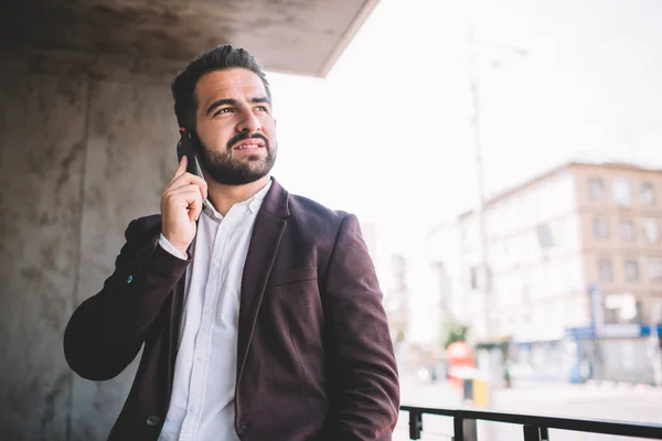 Thoughtful Hispanic Man Suit Looking Away Thinking While Having Smartphone — Stock Photo, Image