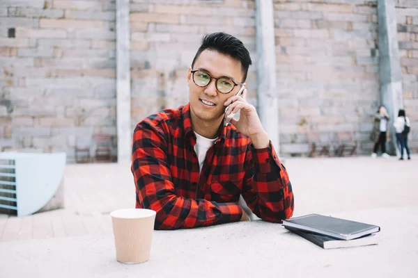 Задумчивый Молодой Задумчивый Жизнерадостный Азиат Очках Клетчатой Рубашке Разговаривающий Телефону — стоковое фото