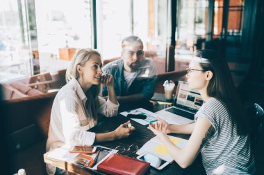 Bir grup kendine güvenen iş adamı kafede toplanıyor ve bilgisayar ve kağıtlarla birlikte masaya otururken başlangıç projesini tartışıyorlar.