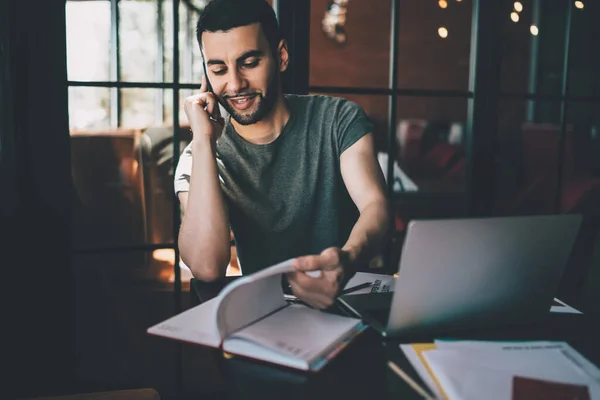 Jovem Feliz Sorrindo Lançando Páginas Planejador Enquanto Sentado Mesa Respondendo — Fotografia de Stock