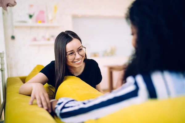 Wanita Tertawa Berambut Panjang Berkacamata Duduk Sofa Kuning Bersandar Bantal — Stok Foto