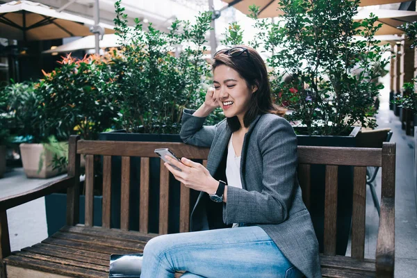 Młoda Atrakcyjna Wesoła Azjatka Formalnych Ciuchach Korzystająca Nowoczesnego Smartfona Zainteresowaniem — Zdjęcie stockowe