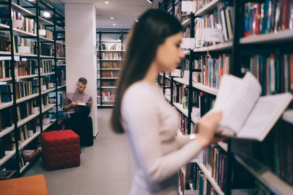 Fokuserad Och Upptagen Manlig Student Sitter Bland Bokhyllor Biblioteket Medan — Stockfoto