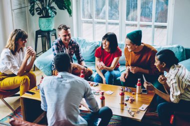 Neşe dolu dalgın hippilerden poker fişleri ile poker oynayıp modern dairede eğlenen