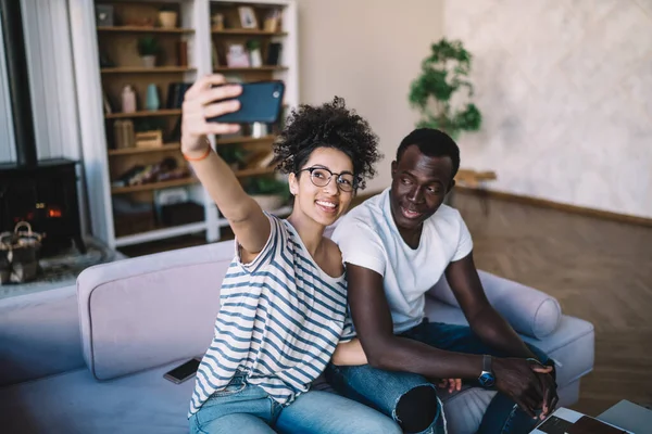 Hombre Afroamericano Vaqueros Rasgados Sentado Sofá Con Alegre Novia Étnica — Foto de Stock