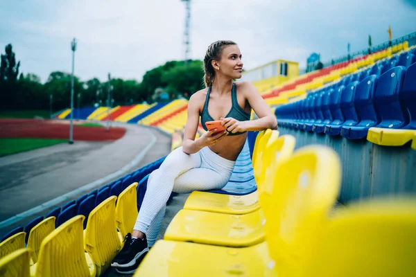 Gülümseyen Kuyruklu Spor Kıyafetler Giyen Akıllı Telefonları Neşeyle Tarayan Stadyumdaki — Stok fotoğraf
