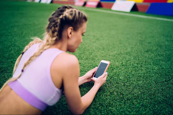 Žena Copánky Sportovním Oblečení Procházení Smartphone Zelené Gras — Stock fotografie