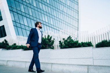 Şık elbiseli, akıllı telefonlu yakışıklı işadamından. Uzaklara bakıyor ve cadde boyunca yürürken şehirdeki bulanık gökdelenlere karşı kafa yoruyor.