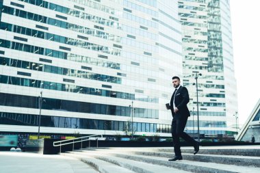 Sabahın köründe modern şehir merkezinde kahve molasında koşan zarif genç işadamının yan görüntüsü.