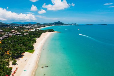 Turkuaz berrak deniz suyuyla beyaz kumsal manzarası. Kumsalda otelleri olan resimli gölün kuş bakışı panoramik manzarası. Tayland 'da nüfuslu bir ada. Su Sporu Etkinliği