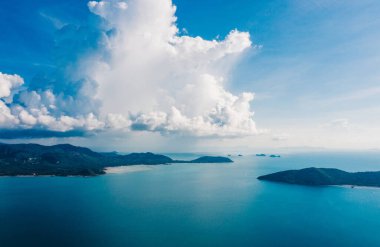 Saf doğayla çevrili boş adaların kuş bakışı görüntüsü. Beyaz bulutlu güzel mavi gökyüzü. Denizle nefes kesici manzara.
