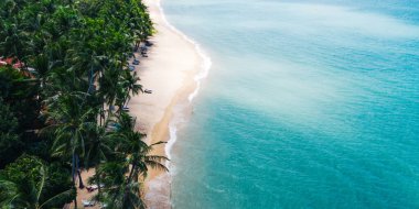 Turkuaz berrak deniz suyu ve köpüklü dalgalarla beyaz kumlu sahil manzarası. Resimli sahil şeridinin kuş bakışı panoramik manzarası. Samui Adası, Tayland