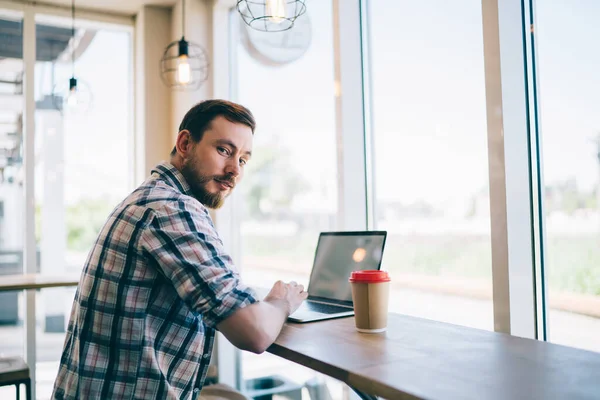 Selvsikker Ung Skjeggete Mann Fritidsklær Som Drikker Kaffe Gjør Prosjekt – stockfoto