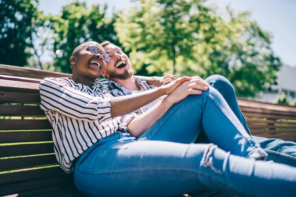 Neşeli Çok Irklı Çiftlerin Parkta Geniş Bir Bankta Sarılıp Gülüşmeleri — Stok fotoğraf