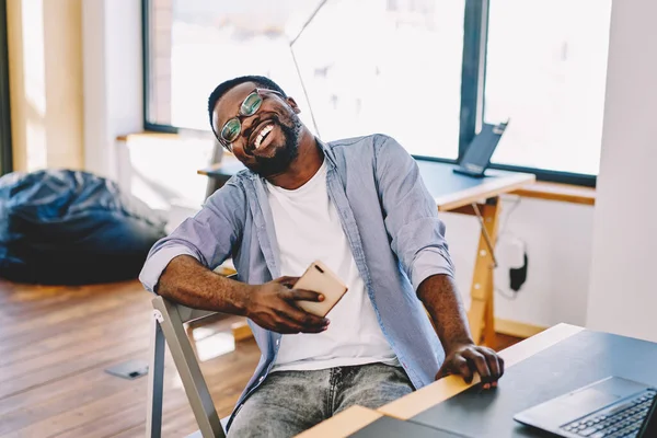 African American Man Glasses Sitting Chair Laughing While Looking Camera — Stock Photo, Image