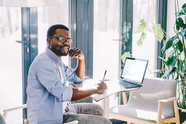 Side View Black Smiling Cheerful Man Taking Notes Notepad Remote — Stock Photo, Image