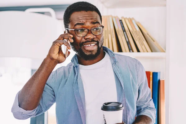 Веселий Афроамериканець Окулярах Розмовляє Мобільному Телефону Тримає Руках Чашку Стоячи — стокове фото