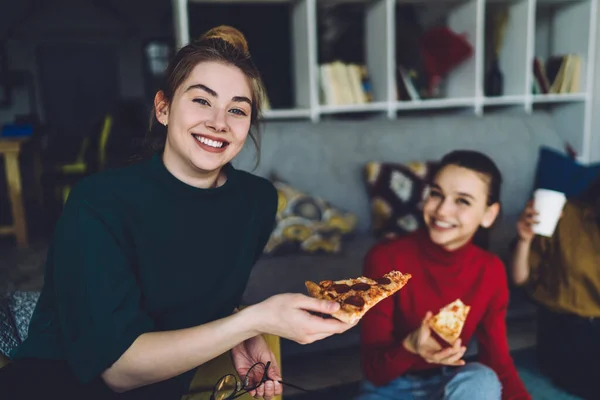 Приємні Усміхнені Жінки Повсякденному Одязі Дивляться Камеру Тримають Шматочки Піци — стокове фото