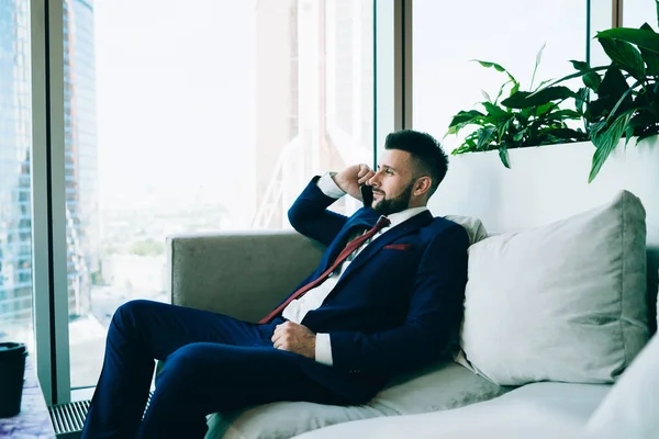 Cara Barbuda Positiva Desgaste Formal Escuro Falando Smartphone Descansando Sofá — Fotografia de Stock