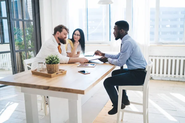 Zijaanzicht Van Tevreden Echtpaar Zitten Aan Tafel Lichte Kamer Glimlachen — Stockfoto