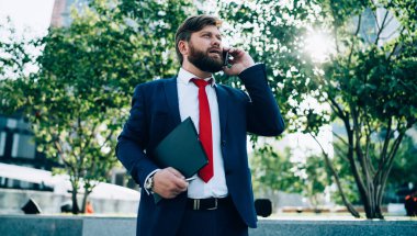 Stresli, takım elbiseli iş adamlarının acil bir sorunu çözmek için telefonda konuştuğu dosyalar ve iş merkezinin yakınındaki bir sokakta taşıdığı belgeler.