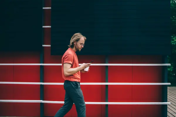 Pandangan Samping Pemuda Berjenggot Modern Hipster Dalam Kemeja Merah Berjalan — Stok Foto