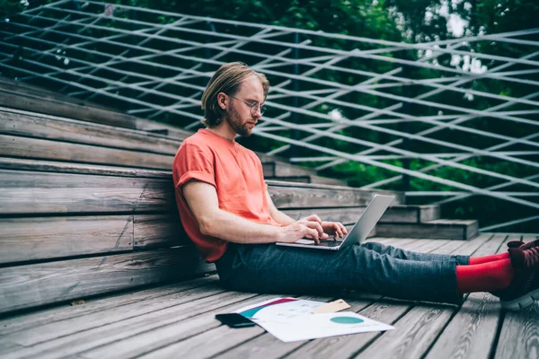 Ung Uppmärksam Man Som Arbetar Bärbar Dator Skriva Medan Sitter — Stockfoto