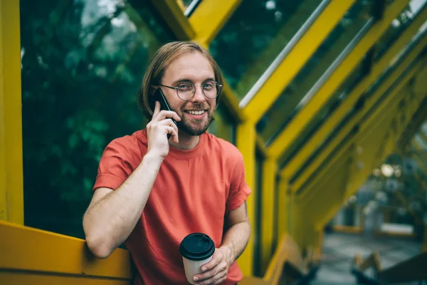 Mladý Ježatý Muž Dívá Kameru Naklání Zábradlí Zatímco Mluví Telefonu — Stock fotografie