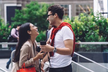 Neşeli, şık bir çift, kentin arka planında sıcak yaz gününde el kamerasıyla birbirlerine bakıp gülüyorlar.